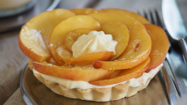 Tortinha de pêssego com massa folhada decorada com fatias da fruta (Créditos: Shutterstock)