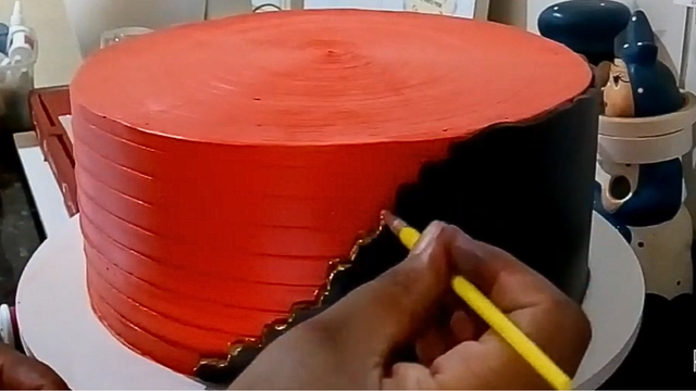 Utilize um pincel comum e pequeno para aplicar um detalhe na parte preta do bolo (Créditos: Reprodução / YouTube @festejandocomalu7674)