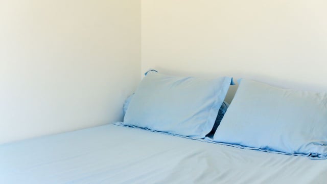 Deixar a lateral da cama encostada na parede pode dar uma maior sensação de segurança, o que favorece um sono mais tranquilo (Créditos: Shutterstock)
