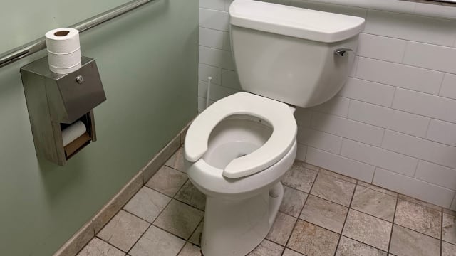 Para que serve a abertura frontal em formato de U nos vasos sanitários de banheiros públicos?