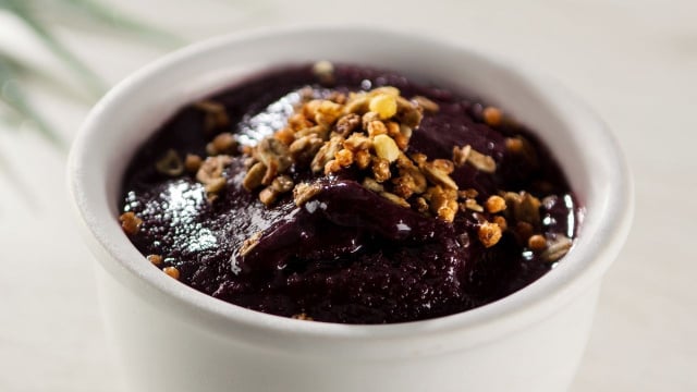 Açaí servido em copo branco finalizado com ingredientes crocantes (Créditos: Shutterstock)