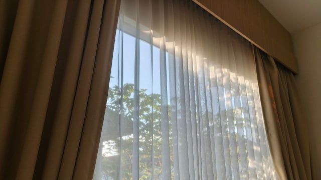 As cortinas e outros itens feitos de tecido devem ser higienizados com certa frequência para evitar o acúmulo de poeira no quarto (Créditos: Shutterstock)
