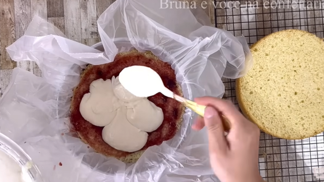 Montagem do bolo recheado com camadas de massa, geleia de morango e creme de ninho trufado. (créditos: créditos: reprodução/Youtube Bruna e você na confeitaria)