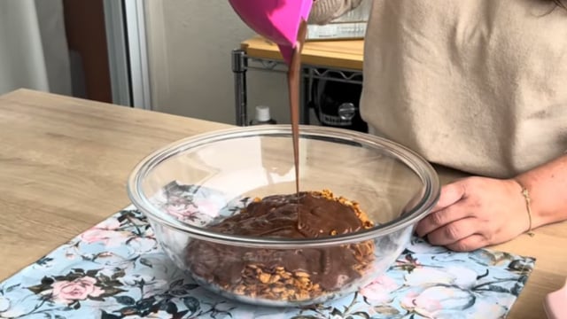 Misture bem todo o chocolate derretido com o cereal de milho para criar uma cobertura crocante (Créditos: Reprodução/ YouTube @AgradávelCozinha)