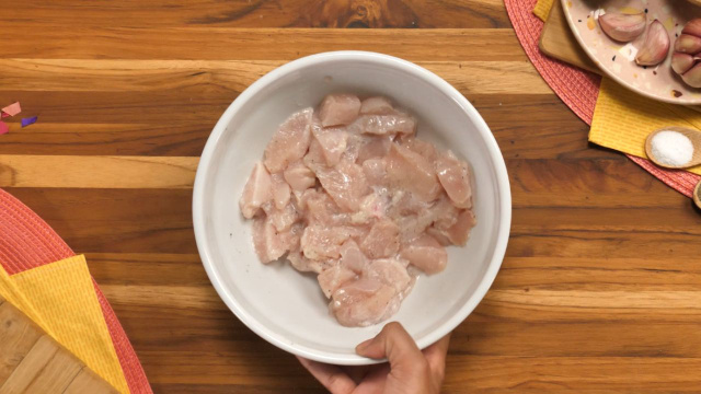 Cubinhos de frango sendo marinados em recipiente (Créditos: TudoGostoso)