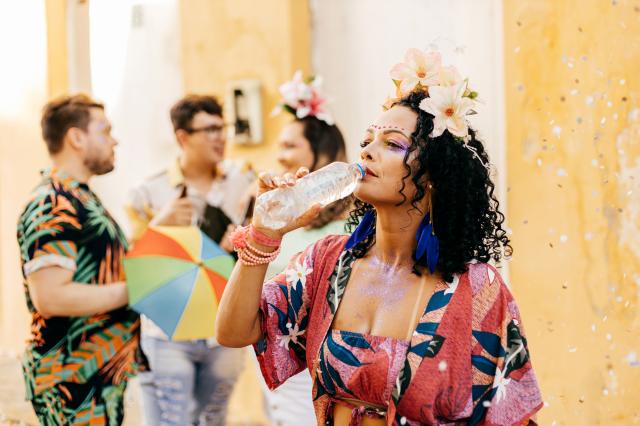 Beber bastante água durante o Carnaval é essencial para não passar mal (Créditos: Shutterstock)