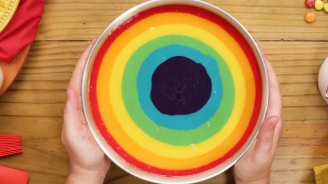 As massas coloridas devem ser despejadas bem no centro da forma para garantirem o efeito visual bonito no bolo arco-íris (Créditos: TudoGostoso)