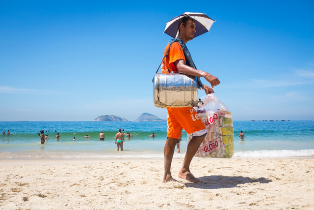Vendedor carrega galões de limão e mate na praia do Rio de Janeiro: dupla é refresco típico. (Crédito: Shutterstock)