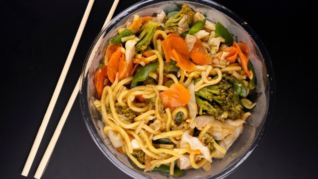 Yakisoba gelado com cenoura, brócolis, pimentão, entre outros, em tigela com hashi (Créditos: Shutterstock)