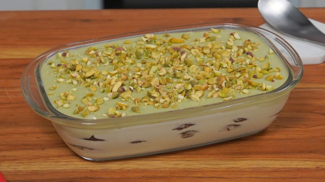 Pavê de pistache em uma travessa com camadas alternadas de creme branco, creme de pistache e biscoitos (Créditos: TudoGostoso)