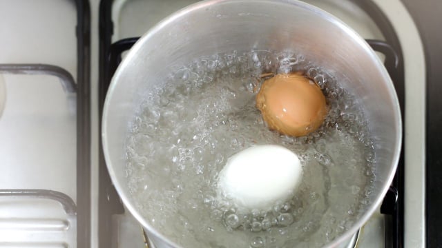 Ovo sendo cozido em água com bicarbonato (Créditos: Canva)