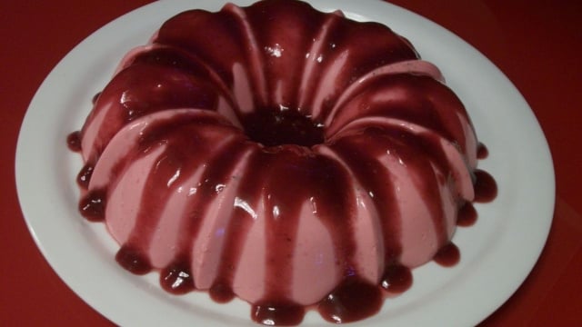 Flan de gelatina com calda de morango servida em prato branco (Créditos: TudoGostoso/Gilda Ferreira Machado)