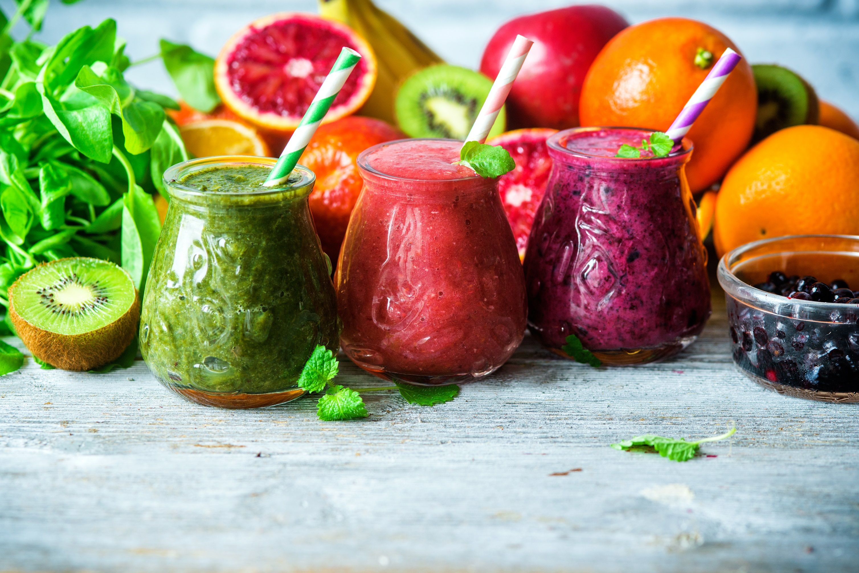 Sucos coloridos: verde, roxo e vermelho com ingredientes para alimentação saudável, desintoxicação ou conceito de comida dietética