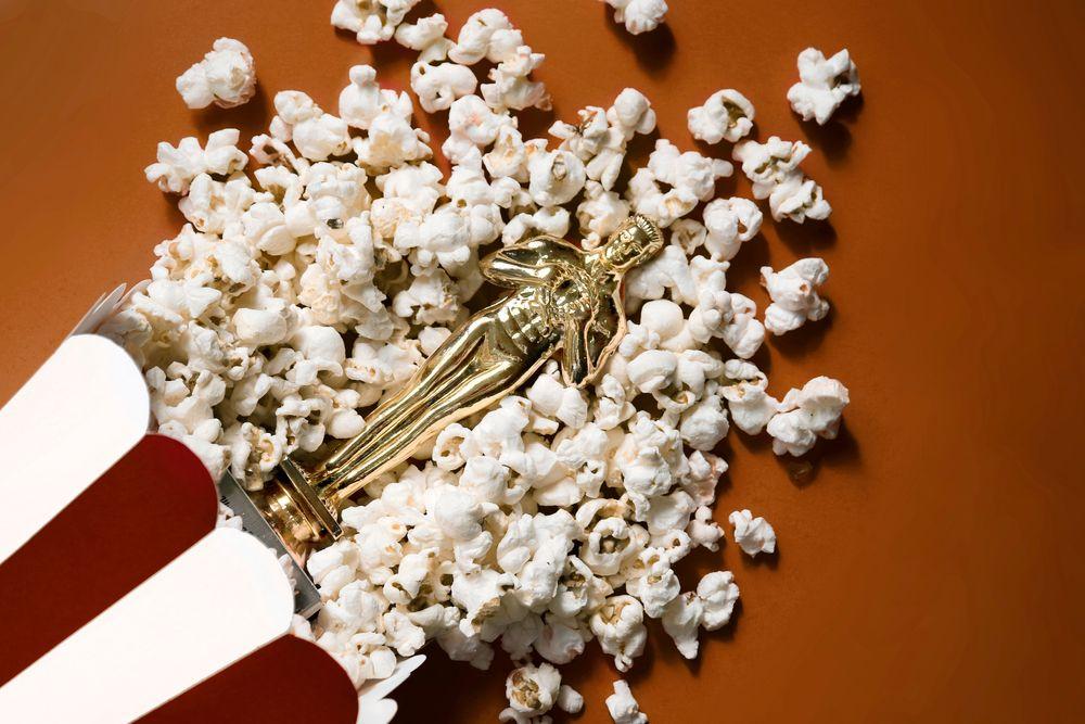 Oscar: mesa marrom com pipoca e uma estatueta dourada em cima