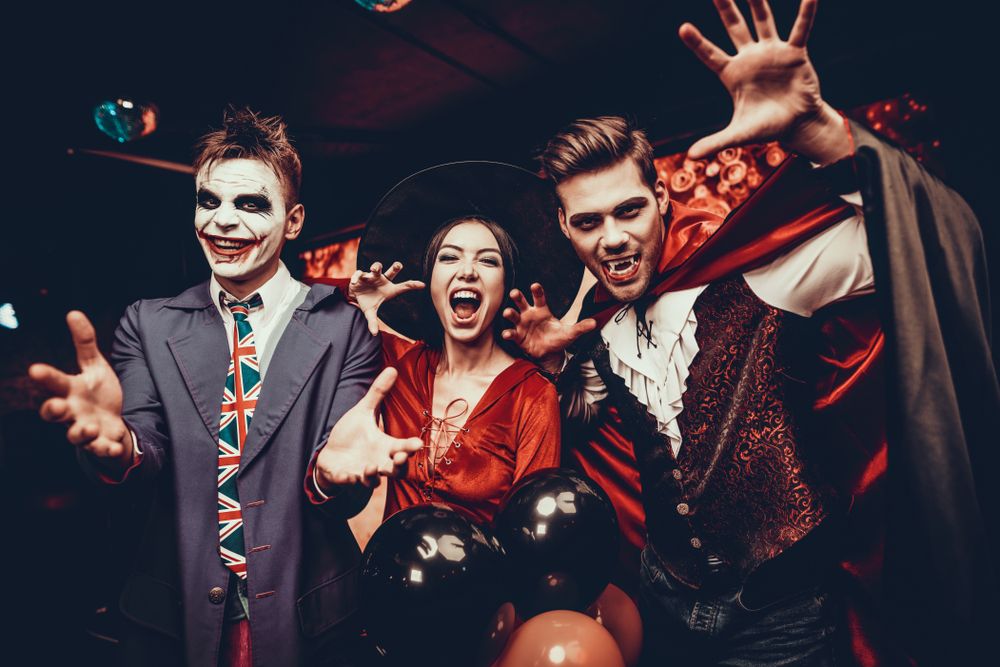 Três jovens com fantasia de vampiros no Halloween