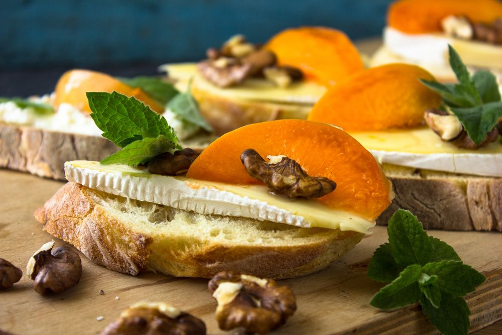 Bruschetta com queijo brie, pêssego, mel e nozes