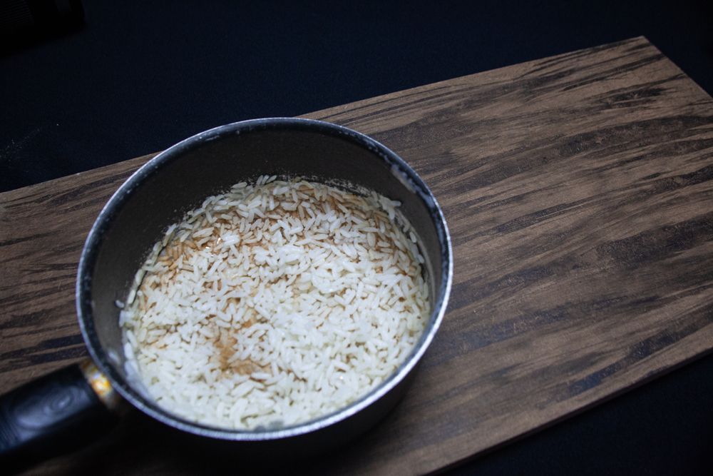 arroz queimado: panela com arroz queimado em cima de uma mesa de madeira