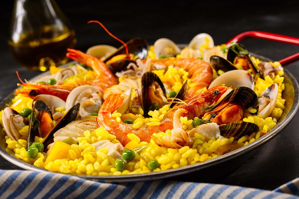 paella com frango e frutos do mar na chapa branca. prato espanhol