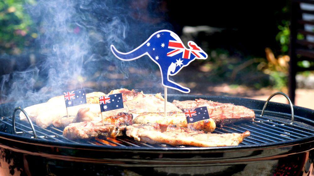 Grelha de churrasco com carnes em cima e bandeiras australianas e cangurus em cima