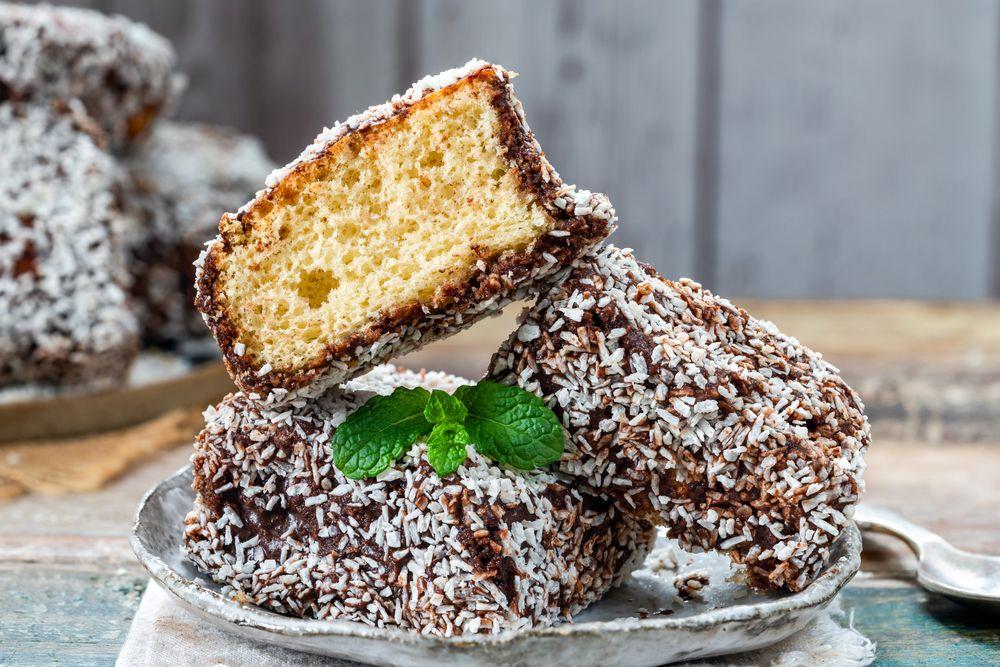 comida australiana com um prato com lamington um bolo de pão sendo dois inteiros e um cortado