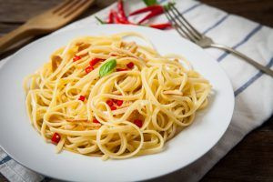 Macarrão alho e óleo servido com pimenta e manjericão