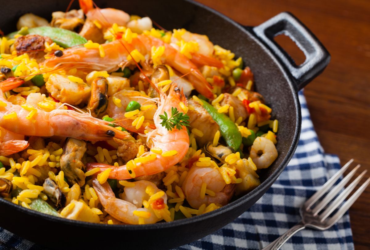 paella com frango e frutos do mar na chapa branca. prato espanhol