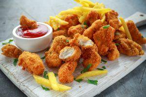 Iscas de frango servidas com batatas fritas e ketchup