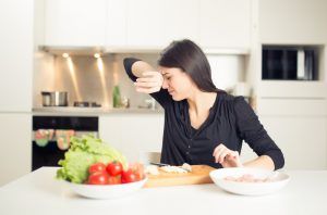 Mulher chorando ao cortar cebola